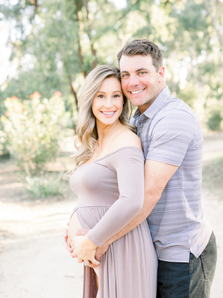 Expecting couple smiling during their maternity photo session