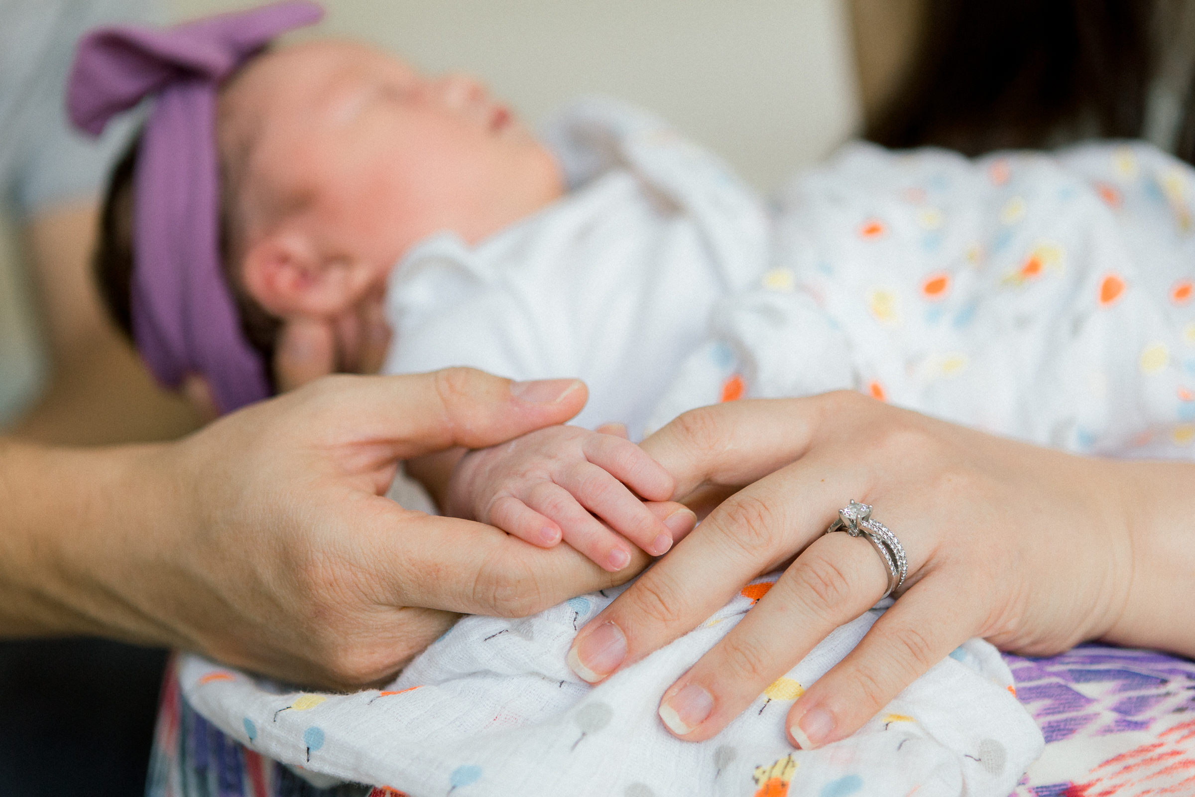 photo of baby holding parent's hands