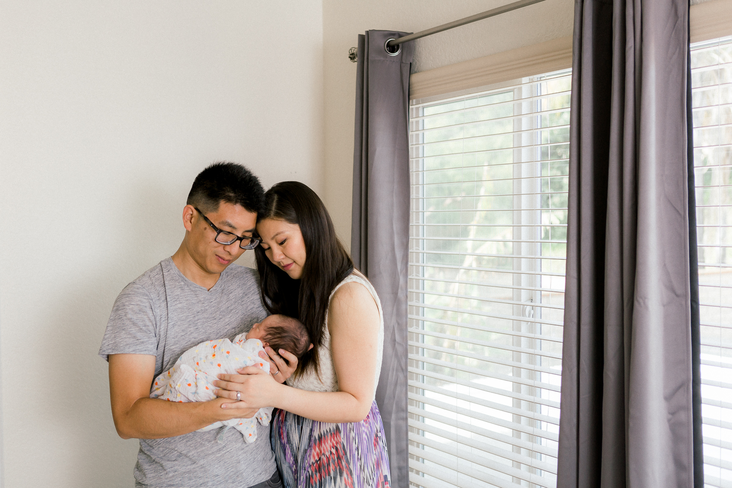 Parents embracing their newborn baby at home