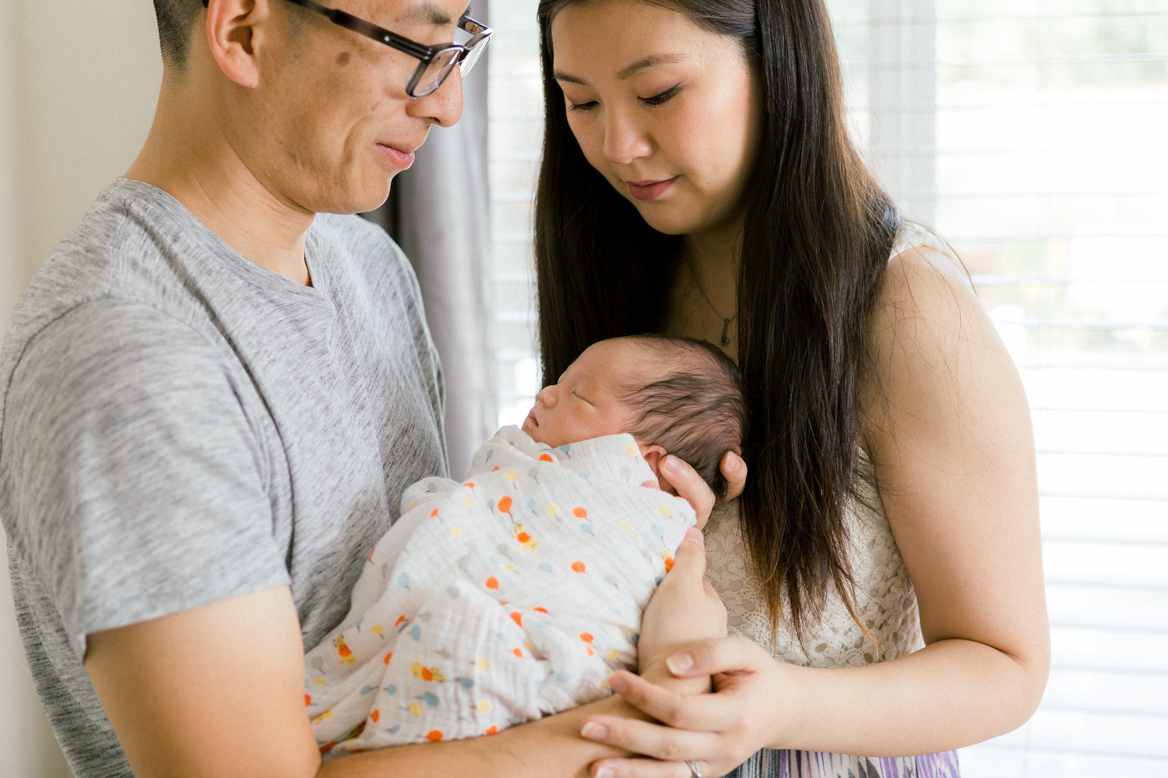 Parents embracing their newborn baby at home