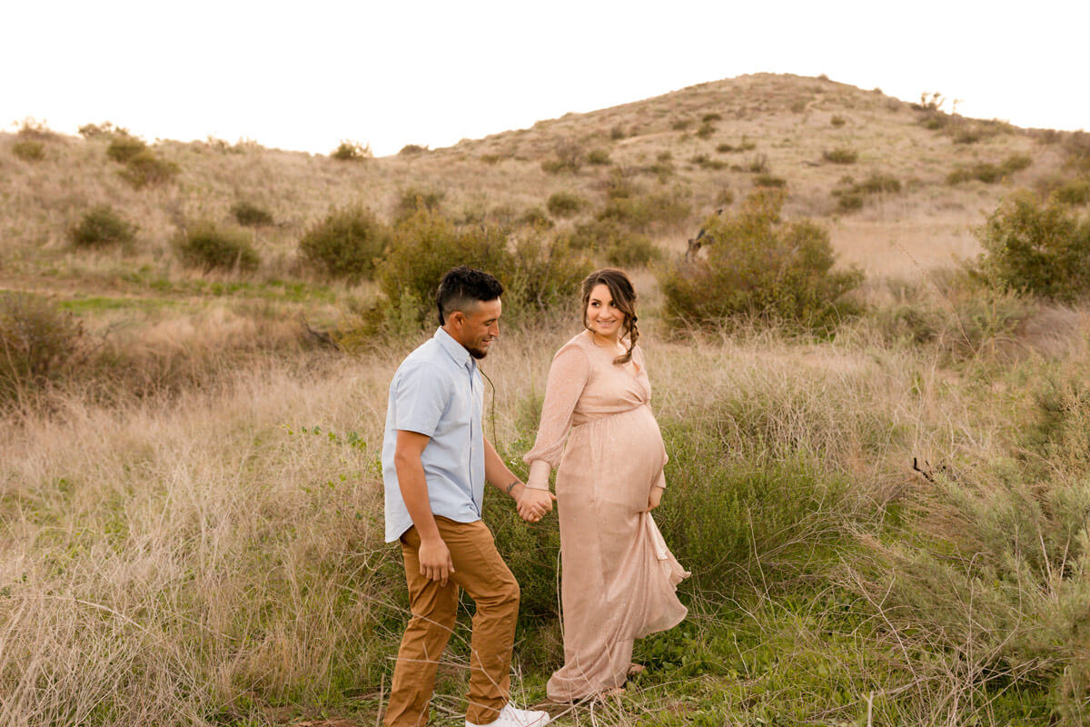 Pregnant couple walking in the fields