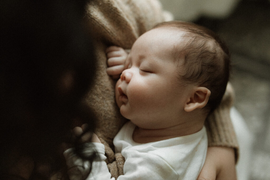 A detail photo of baby's face against mom's chest.